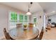 Bright dining room with a rustic table, views of a green backyard, and comfortable seating at 3982 Ivory Gables Pl, Buford, GA 30519