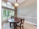 Dining room with a round wooden table, chairs, and large windows providing natural light at 3982 Ivory Gables Pl, Buford, GA 30519