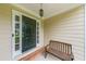 Cozy front porch with a dark front door and a wooden bench at 3982 Ivory Gables Pl, Buford, GA 30519