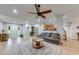 Bright living room featuring a ceiling fan, hardwood floors, and views into the kitchen and entrance at 3982 Ivory Gables Pl, Buford, GA 30519