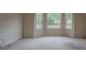 Bright bedroom featuring a bay window with a lovely view, plush carpet, and neutral paint at 4952 Terrace Dr, Ellenwood, GA 30294