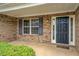 Inviting front entrance features a dark-colored door, sidelights, and brick surround with green bushes and an outdoor light at 4952 Terrace Dr, Ellenwood, GA 30294