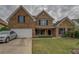 Charming two-story brick home with landscaped front yard, dark shutters and a two car garage on an overcast day at 4952 Terrace Dr, Ellenwood, GA 30294