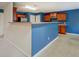 Open kitchen features blue accent wall with peninsula counter and view into other rooms at 4952 Terrace Dr, Ellenwood, GA 30294