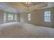 Spacious carpeted main bedroom boasts a trey ceiling and abundant natural light from large windows at 4952 Terrace Dr, Ellenwood, GA 30294