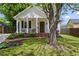 Charming home featuring a landscaped yard and welcoming front porch with brick steps and seating area at 94 Glenn Se St, Atlanta, GA 30312