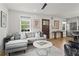Open-concept living space featuring a modern sofa, hardwood floors, and seamless flow to the kitchen at 94 Glenn Se St, Atlanta, GA 30312
