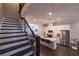 Spacious staircase leading to a modern kitchen with stainless steel appliances and a marble island at 10143 Windalier Way, Roswell, GA 30076