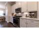 Modern kitchen with white cabinets, stainless steel appliances, and dining area in the background at 10143 Windalier Way, Roswell, GA 30076