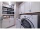 Laundry room with washer, dryer, cabinets, and open shelving at 10143 Windalier Way, Roswell, GA 30076