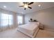 Spacious primary bedroom with neutral colors, carpeted floors, and ceiling fan at 10143 Windalier Way, Roswell, GA 30076