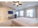 Stylish bedroom features a wood accent wall, a TV and carpeted floors at 10143 Windalier Way, Roswell, GA 30076