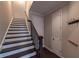 Hallway featuring a staircase with black wood stairs and railing at 10143 Windalier Way, Roswell, GA 30076