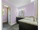 Bathroom with dark brown vanity, double mirrors, gray tile floor, and purple wall at 1402 Bromley Dr, Snellville, GA 30078