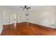 Large bedroom with rich hardwood floors, ceiling fan, and double doors leading to the ensuite bath at 1402 Bromley Dr, Snellville, GA 30078