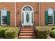 Elegant front door with decorative glass, framed by green shutters and manicured landscaping at 1402 Bromley Dr, Snellville, GA 30078