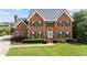 Charming brick home featuring a manicured lawn, green shutters, and a welcoming front entrance at 1402 Bromley Dr, Snellville, GA 30078