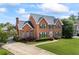 Elegant brick home with a well-kept lawn, complemented by mature trees and attractive landscaping at 1402 Bromley Dr, Snellville, GA 30078