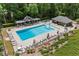 Aerial view of the community pool with lounge chairs, umbrellas, and a covered seating area at 1402 Bromley Dr, Snellville, GA 30078