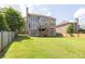 Spacious backyard with a well-maintained lawn, fenced perimeter, and rear exterior of the home at 1584 Heartland Path, Hoschton, GA 30548