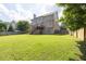 Lush backyard showcasing the home's exterior, fenced yard, mature trees and lawn at 1584 Heartland Path, Hoschton, GA 30548
