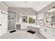 Bright bathroom boasts a soaking tub, glass enclosed shower, and double vanity sinks at 1584 Heartland Path, Hoschton, GA 30548