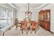 Elegant dining room with a chandelier, large windows, and classic wooden furniture at 1584 Heartland Path, Hoschton, GA 30548