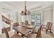 Elegant dining room with a chandelier, large windows, and classic wooden furniture at 1584 Heartland Path, Hoschton, GA 30548