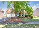 Charming two-story brick home featuring a well-manicured lawn and a two-car garage at 1584 Heartland Path, Hoschton, GA 30548