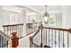 Upstairs hallway featuring staircase and a light fixture at 1584 Heartland Path, Hoschton, GA 30548