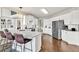White kitchen features stainless steel appliances, stone countertops, and a breakfast bar at 1584 Heartland Path, Hoschton, GA 30548