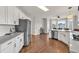 Bright kitchen with stainless steel appliances, white cabinets and hardwood floors at 1584 Heartland Path, Hoschton, GA 30548