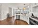 Bright kitchen with stainless steel appliances, white cabinets and hardwood floors at 1584 Heartland Path, Hoschton, GA 30548