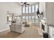 Bright living room with high ceilings, fireplace, and large windows offering scenic views at 1584 Heartland Path, Hoschton, GA 30548