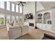 Spacious living area with large windows, a fireplace, and custom built-in shelving at 1584 Heartland Path, Hoschton, GA 30548