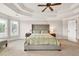 Spacious main bedroom featuring tray ceilings, a ceiling fan, and large windows at 1584 Heartland Path, Hoschton, GA 30548