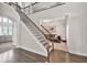 Grand foyer with hardwood floors and an elegant staircase featuring dark wood and decorative iron railings at 1584 Heartland Path, Hoschton, GA 30548