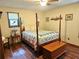 Bedroom with hardwood floors, a four-poster bed, and warm, inviting decor at 162 Apple Valley Dr, Woodstock, GA 30188