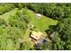 An aerial view of the home, barn, and surrounding property with mature trees at 6980 Lamplighter Ln, Winston, GA 30187