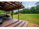 Relaxing backyard showcasing a spacious lawn, fire pit, and covered patio at 6980 Lamplighter Ln, Winston, GA 30187