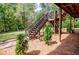 Backyard view of deck stairs surrounded by landscaping and wooded area at 6980 Lamplighter Ln, Winston, GA 30187