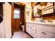 Bathroom featuring white cabinets, double sinks, and a wood-paneled section with toilet and shower at 6980 Lamplighter Ln, Winston, GA 30187