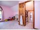 Bedroom with plush carpet, light pink walls, and a doorway leading to a connected room at 6980 Lamplighter Ln, Winston, GA 30187