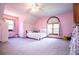 Comfortable bedroom featuring neutral carpeting, light-pink walls, and a window providing natural light at 6980 Lamplighter Ln, Winston, GA 30187