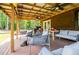 A cozy, covered patio featuring comfortable seating, ceiling fans, and an outdoor grill at 6980 Lamplighter Ln, Winston, GA 30187