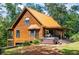 A log cabin with a metal roof, a covered patio, and a hot tub surrounded by lush greenery at 6980 Lamplighter Ln, Winston, GA 30187