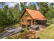 A rustic log cabin with a covered patio, a hot tub, and surrounded by lush greenery at 6980 Lamplighter Ln, Winston, GA 30187
