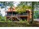 Rustic log cabin-style home with a metal roof and a spacious deck and outdoor staircase at 6980 Lamplighter Ln, Winston, GA 30187