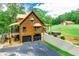 Scenic view of a log home featuring a garage, spacious deck, and green surroundings at 6980 Lamplighter Ln, Winston, GA 30187