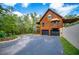 Charming log cabin with an asphalt driveway, a two-car garage, and beautiful wooded surroundings at 6980 Lamplighter Ln, Winston, GA 30187